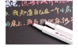 Close-up of metallic color brush pens showing high-coverage ink on black paper