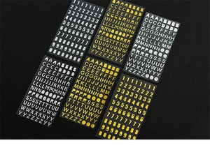 Detail of gold and silver metallic alphabet and number stickers on a black background