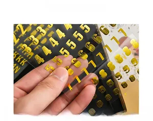 Close-up of gold foiled alphabet and number stickers with embossed metallic texture