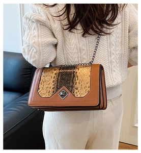 Detail of snakeskin patchwork flap bag with metallic diamond buckle on model back