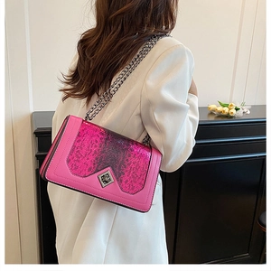 Macro detail of pink snake-print leather crossbody bag with silver geometric buckle
