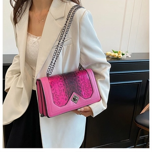 Detail of rose pink leather crossbody bag with snakeskin flap and metal chain strap