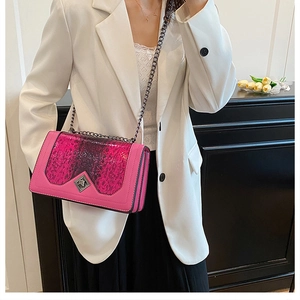 Detail of snake skin pattern stitching and metal chain on pink crossbody bag