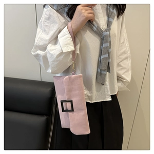 Pink envelope clutch with square metal buckle and wristlet strap detail view