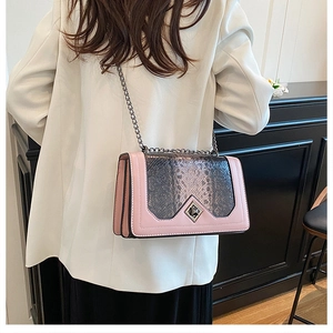 Detail of pink snake pattern crossbody bag with metallic diamond clasp and chain strap
