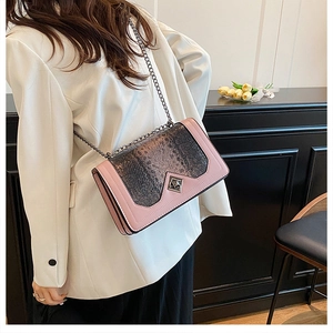 Detail of pink and snake skin textured leather crossbody bag with metal chain strap