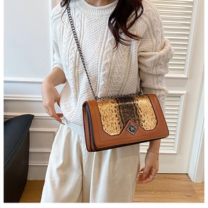 Detail of snake skin pattern flap and diamond metal lock on a vintage shoulder bag