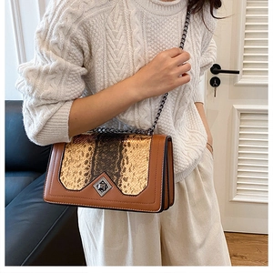Close-up of snake skin pattern stitching and metallic diamond lock on brown chain bag