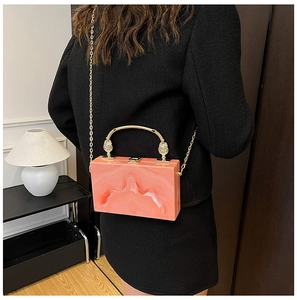 Achteraanzicht van model met roze marmeren acryl box bag met gouden handvat en ketting