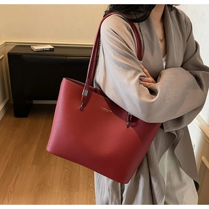 Close-up of red large tote bag featuring lychee texture and metallic silver hardware