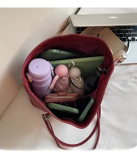 Interior view showing large capacity of red tote bag with daily items and laptop