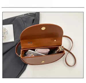 Interior capacity of the brown saddle bag showing space for phone and makeup
