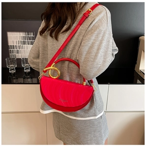 Detail of rose red semi-circle bag with wave texture and gold circular handle