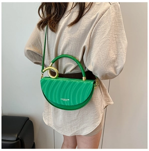 Detail of green crescent bag featuring unique wave texture and gold ring buckle