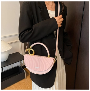 Detail of pink half-moon leather bag with gold handle and fashion text held by model