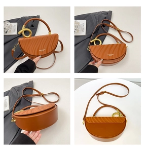 Detail of caramel brown moon bag with wave texture leather and golden ring buckle