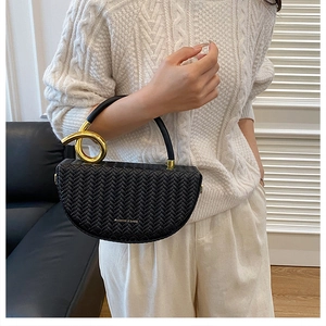 Vue détaillée du sac demi-lune tissé noir avec d'élégants détails en métal doré noué
