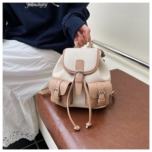 Dettaglio dello zaino in tela e pelle con tasche frontali e chiusura a coulisse