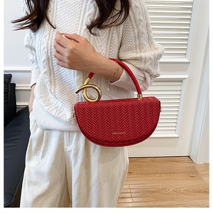 Détail du sac rouge tissé avec poignée métallique dorée et inscription Fashion moderne