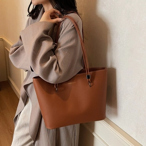 Elegant brown leather tote bag with LIVRES & LOVE print and slim shoulder straps