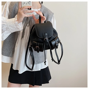 Mini zaino nero indossato da una modella con design multitasche e fibbie argentate