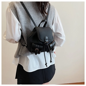 Dettaglio del retro di un mini zaino in pelle PU nera con patta e chiusura a coulisse regolate