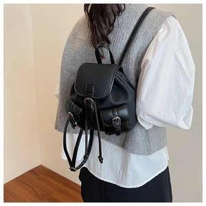 Modella che indossa un mini zaino in finta pelle nera con coulisse e tasche con fibbia