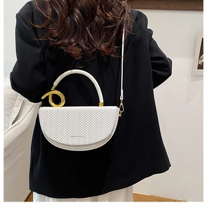 Détail d'un sac demi-lune blanc tissé avec des anneaux dorés et un logo de mode chic