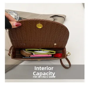 Détail du sac bandoulière marron tressé montrant sa capacité interne pour accessoires