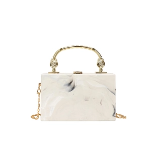 Acrylic evening clutch in white marble finish with gold handle and chain strap