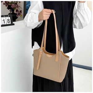 Detail shot of khaki tote bag with premium leather handles and elegant metal buckle