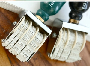 Vue macro du tampon dateur rotatif vintage avec roues en caoutchouc réglables et cadre métal
