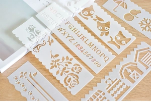 Detailed view of various white hollow stencils for DIY drawing and bullet journaling