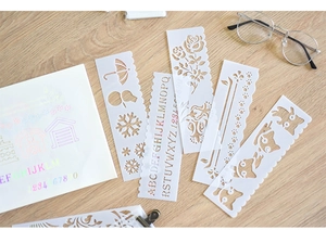Close-up of flexible DIY drawing stencils with floral patterns on a wooden desk