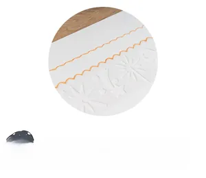 Detail of white hollow drawing stencil showing embossed star patterns and wavy orange lines