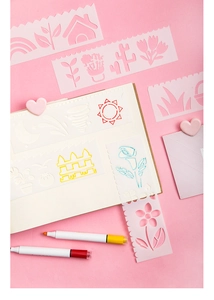 Detail of translucent floral painting stencil with heart clips and colored markers
