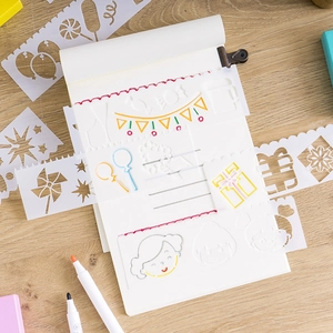 Translucent hollow plastic painting templates with festive patterns on a wooden desk