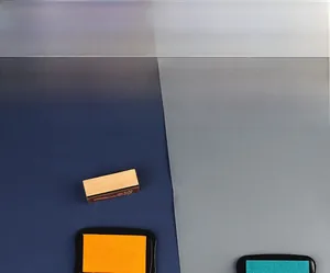 Detail view of orange and green ink pads for stamps with a wooden handle on a blue background