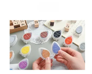 Close-up of colorful droplet ink pads for rubber stamps on a wooden desk setup
