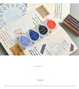 Macro detail of teardrop ink pads in assorted colors on a vintage scrapbook setup