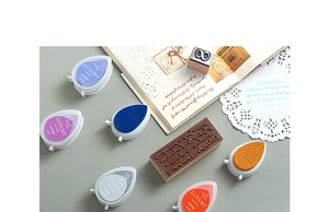 Detailed view of teardrop ink pads in assorted colors with a vintage diary background