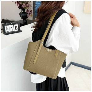 Detail view of olive green leather tote bag with silver buckle and embossed side logo tag