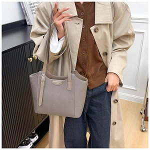 Detailed close-up of a large capacity leather tote bag with adjustable shoulder strap