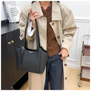 Close-up of black leather tote bag featuring silver hardware and luxury lychee texture