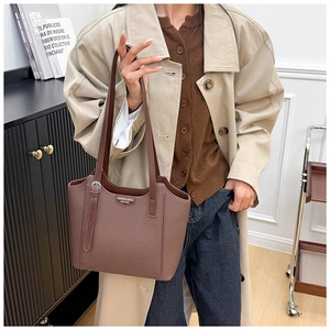 Detail of vintage brown leather tote bag showing fine texture and fashion metal buckle