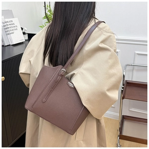 Detail of retro brown leather tote with adjustable shoulder strap and fashion label