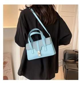 Sky blue textured handbag detail showing the turn-lock closure and woven flap texture