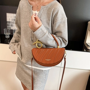 Brown leather half-moon box bag with wave patterns and golden metal knot handle