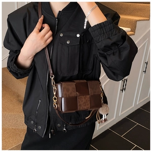 Detailed shot of brown woven crossbody bag with leopard print texture and gold chain strap