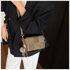 Close-up of woven crossbody bag with brown faux leather and leopard print panels
